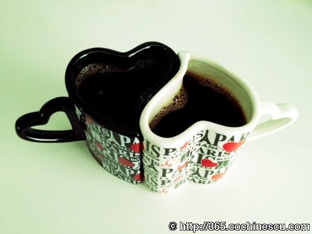 Two heart-shaped mugs, one white and one black, are placed together.