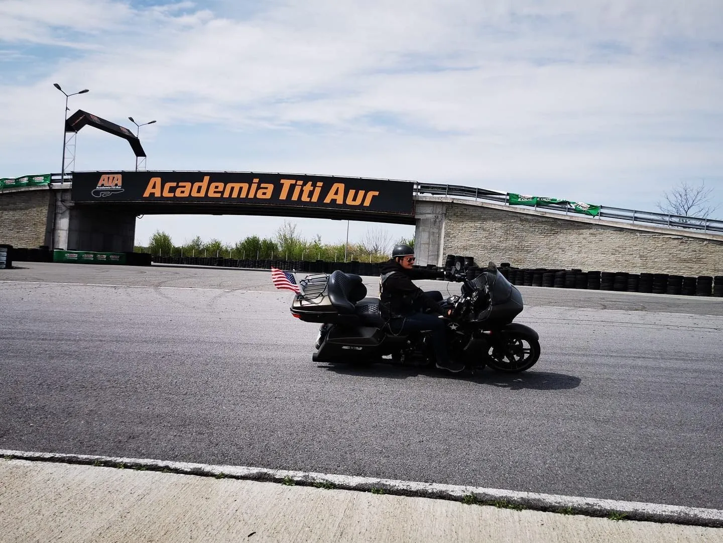 Un motociclist conduce o motocicletă de touring pe circuitul de antrenament al Academiei Titi Aur.
