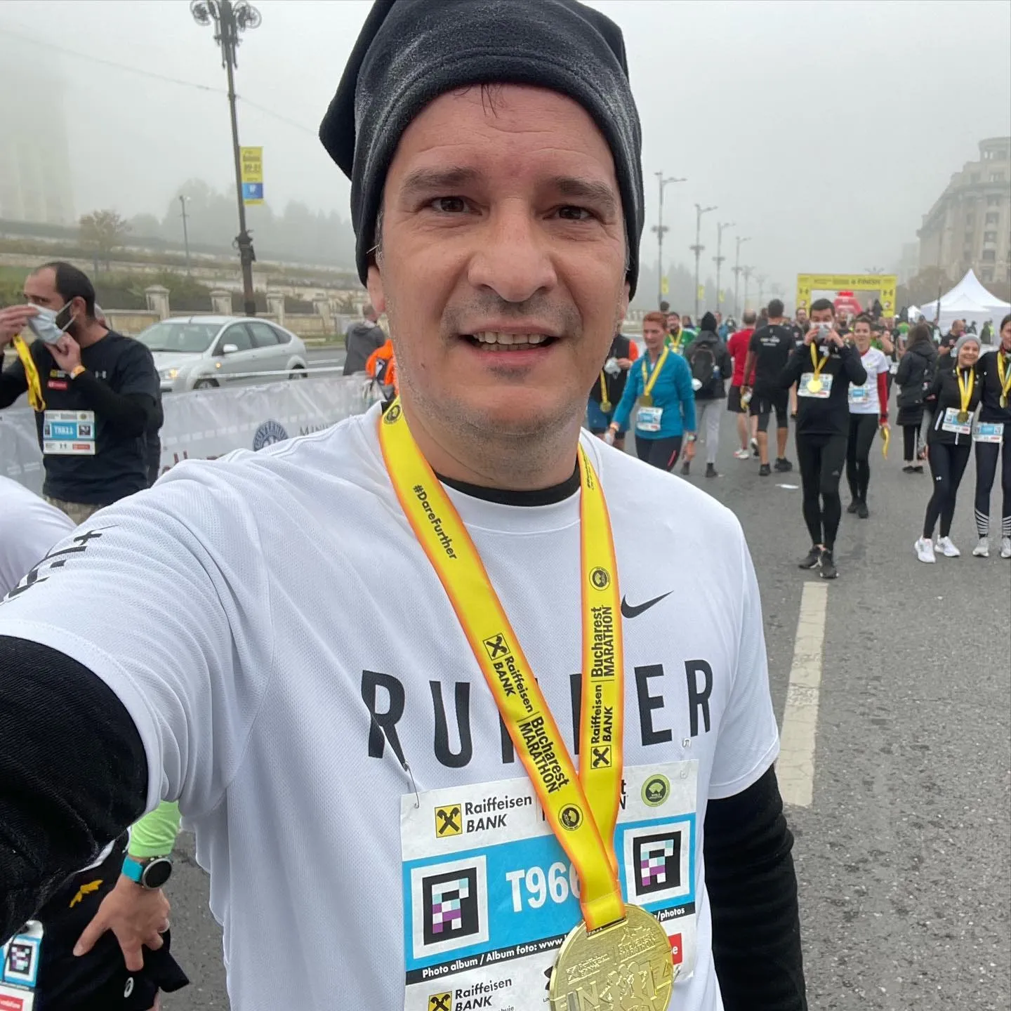Sebastian Cochinescu își face un selfie purtând medalia de finisher la Maratonul București, pe o vreme cețoasă.