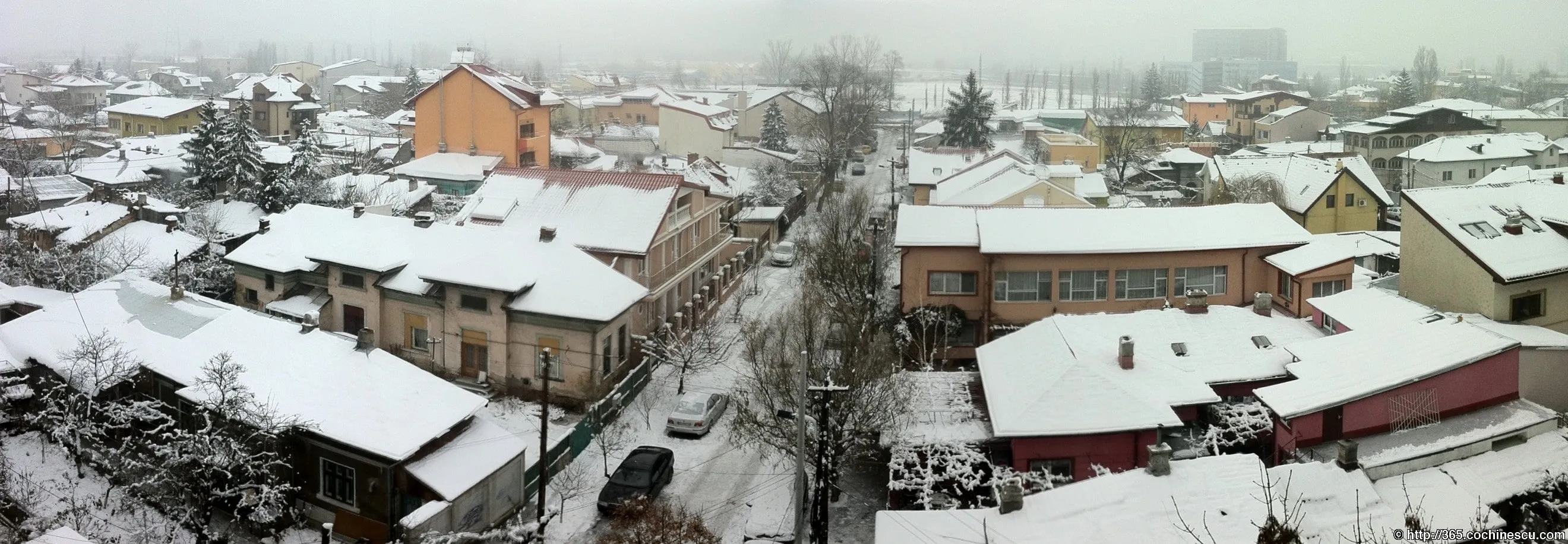 The houses and streets of a Bucharest neighborhood are covered in snow.