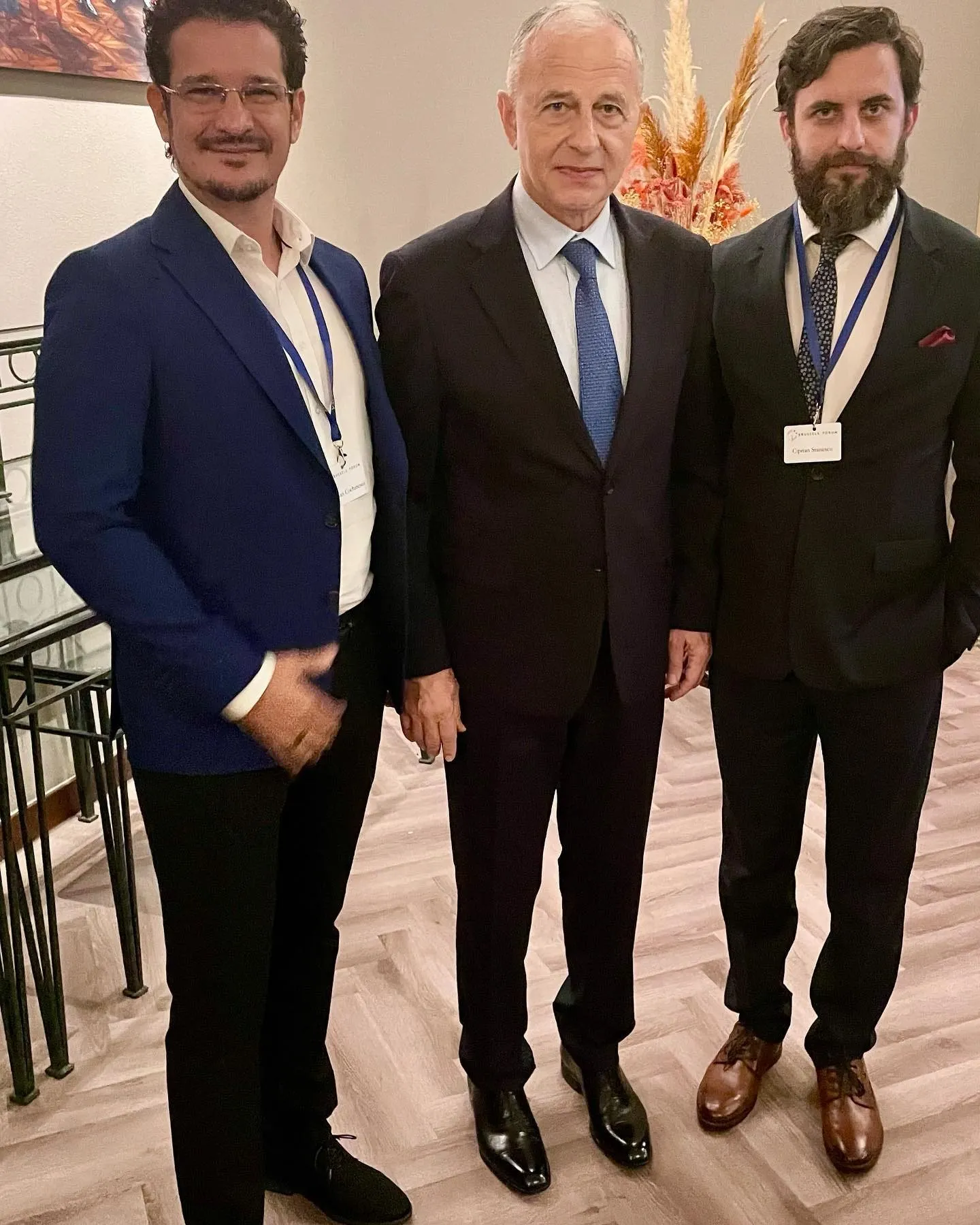 Sebastian Cochinescu alături de doi participanți îmbrăcați elegant la Brussels Forum.