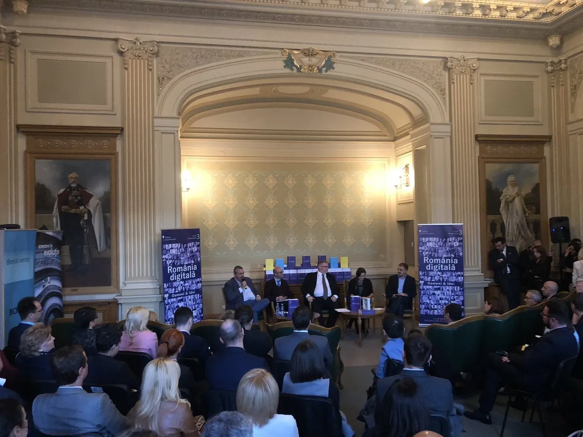 Five people sit on a stage in an ornate hall, between Digital Romania banners, in front of a full audience.