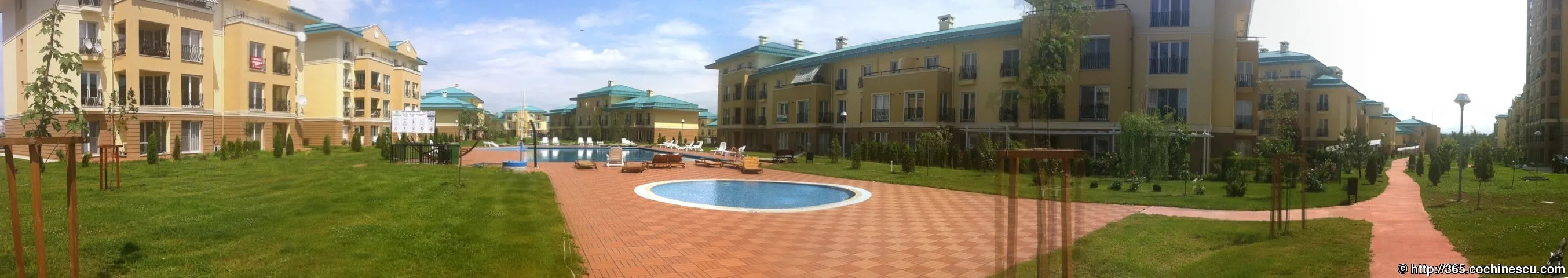 O panoramă prezintă grădina, aleile și piscinele dintre clădirile din Cosmopolis.